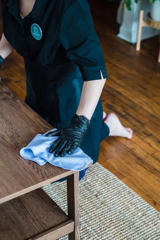 Technician deep cleaning hardwood flooring after water damage restoration