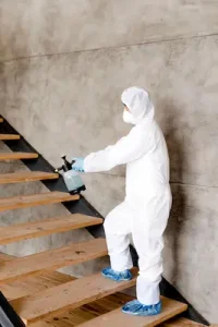 Technician removing mold from a basement staircase after water damage